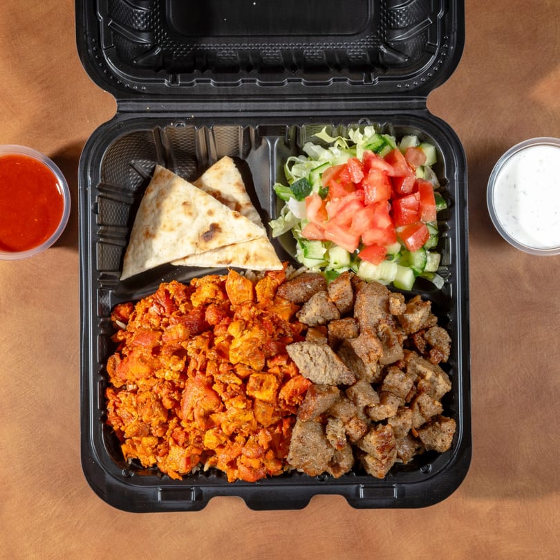 Zaytoon's Afghan combo meal with chicken, beef, salad, naan, and sauces in a takeout container.